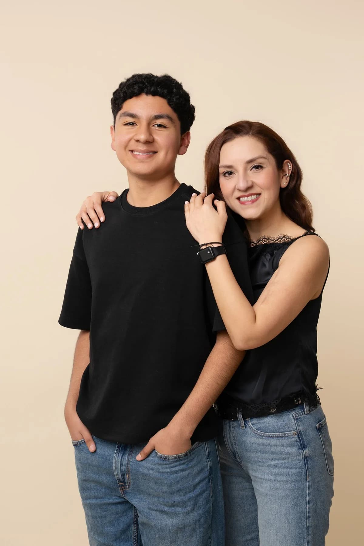 Two people standing together in coordinated black tops and jeans