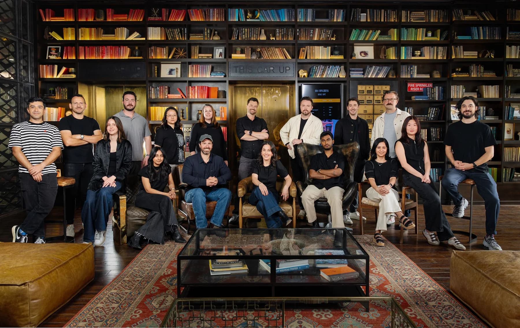 Company team posed together in a warmly lit library