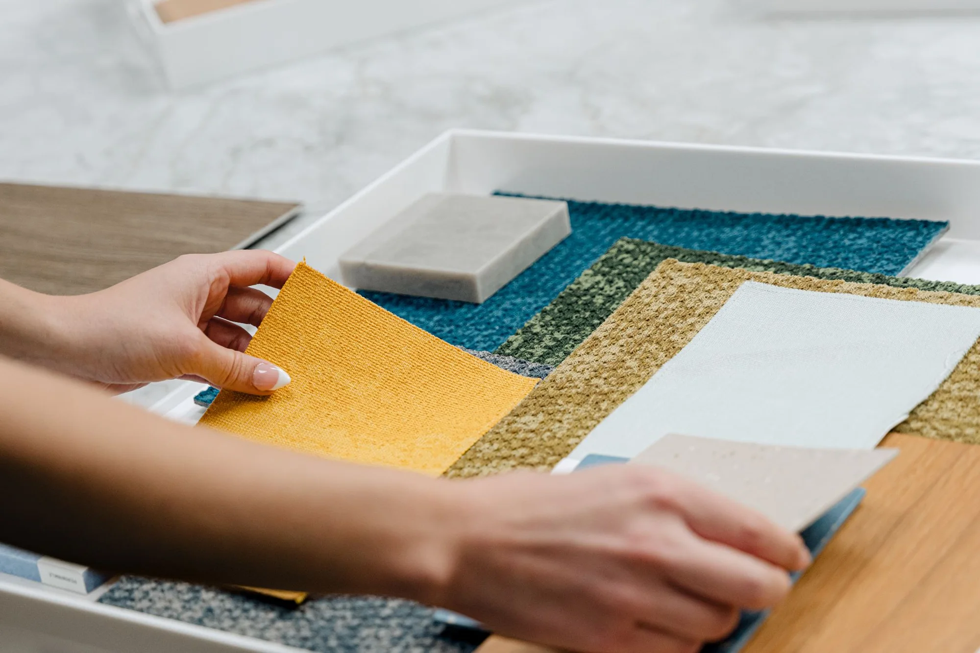 Hands arranging colorful fabric and finish samples at FGM Architects