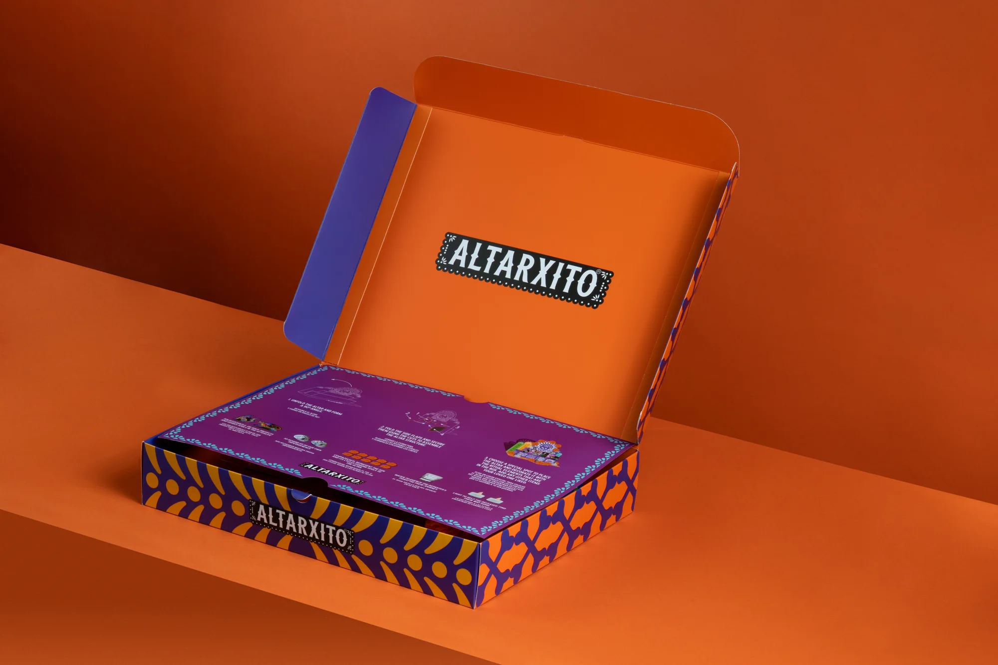 Open purple Altarxito product box photographed against an orange backdrop